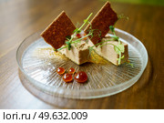 Plate of foie micuit with crispy croutons and drops of marmalade on a wooden table in a fine dining restaurant.. Plate of foie micuit with crispy croutons and drops of marmalade. Стоковое фото, агентство Ingram Publishing / Фотобанк Лори