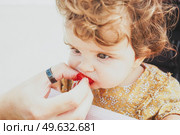Little baby girl eating a strawberry. Стоковое фото, агентство Ingram Publishing / Фотобанк Лори