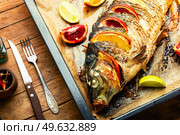 Delicious fish carp grilled whole with lemon and oranges.. Appetizing roasted carp. Стоковое фото, агентство Ingram Publishing / Фотобанк Лори
