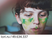 Moody portrait of a young woman with her face painted of green. Стоковое фото, агентство Ingram Publishing / Фотобанк Лори