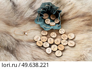 Handmade runes for fortunetelling in leather bag over wolf fur. Handmade runes for fortunetelling. Стоковое фото, агентство Ingram Publishing / Фотобанк Лори