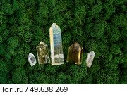 gemstones minerals mix on mysterious natural forest moss background, quartz and calcite crystals close up top view . Magic healing Rock for Reiki Crystal Ritual, Witchcraft. Healing crystals on brown background. Стоковое фото, агентство Ingram Publishing / Фотобанк Лори