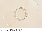 Glass petri dish with transparent pure serum for skin care on beige background, top view. Concept laboratory tests and research. Glass petri dish with transparent pure serum for skin care. Стоковое фото, агентство Ingram Publishing / Фотобанк Лори