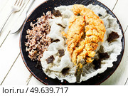 Deep fried sea bass fish with rice on rice paper. Roasted seafood. Tasty fried sea bass fish. Стоковое фото, агентство Ingram Publishing / Фотобанк Лори