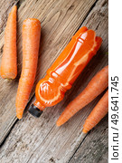 fresh carrot juice with carrots around old style wooden background . Стоковое фото, агентство Ingram Publishing / Фотобанк Лори