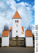 Gate to a beuatiful white church with red tiled roof under a blue sky. Стоковое фото, агентство Ingram Publishing / Фотобанк Лори