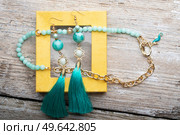 beautiful handmade  turquoise  jewelry with natural gems in yellow box around old style wooden background. close up. fashion concept. Стоковое фото, агентство Ingram Publishing / Фотобанк Лори