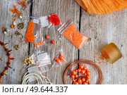 orange set for handmade jewelry with necklace  around white old style wooden background. close up. Стоковое фото, агентство Ingram Publishing / Фотобанк Лори