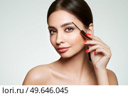 Beautiful woman puts mascara on her eyebrows. Eyelash extensions. Healthy clean fresh skin natural make up beauty eyes. Стоковое фото, агентство Ingram Publishing / Фотобанк Лори