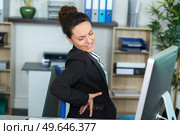woman with back problems in the office. Стоковое фото, агентство Ingram Publishing / Фотобанк Лори