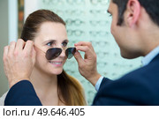 optician fitting prescription sunglasses on client. Стоковое фото, агентство Ingram Publishing / Фотобанк Лори