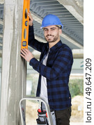 handyman professional with spirit level working on home renovations. Стоковое фото, агентство Ingram Publishing / Фотобанк Лори
