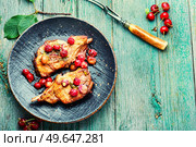 Two cooked steaks in a cherry marinade. Fried meat with berry sauce on old wooden background. Space for text. Meat on the bone roasted in berry sauce. Стоковое фото, агентство Ingram Publishing / Фотобанк Лори