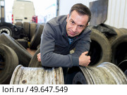 vulcanizing worker posing on a tire rim. Стоковое фото, агентство Ingram Publishing / Фотобанк Лори