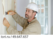 professional male builder stripping wallpaper. Стоковое фото, агентство Ingram Publishing / Фотобанк Лори