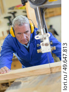 senior man wearing ear protectors while using table saw. Стоковое фото, агентство Ingram Publishing / Фотобанк Лори