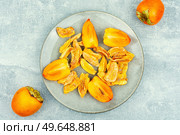 Sweet dried persimmon on the plate. Healthy vegan snacks. Tasty dried persimmon, healthy snacks. Стоковое фото, агентство Ingram Publishing / Фотобанк Лори