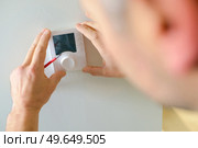 Electrician fitting a thermostat. Стоковое фото, агентство Ingram Publishing / Фотобанк Лори