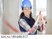 female worker erecting exclusion chain in renovation property. Стоковое фото, агентство Ingram Publishing / Фотобанк Лори