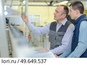 Worker holding up object to inspect it. Стоковое фото, агентство Ingram Publishing / Фотобанк Лори