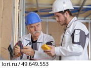 builder insulating wooden house with mineral rock wool. Стоковое фото, агентство Ingram Publishing / Фотобанк Лори