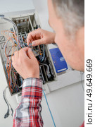 Electrican connecting fuse box. Стоковое фото, агентство Ingram Publishing / Фотобанк Лори