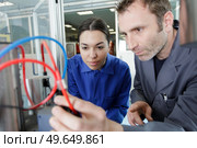 two maintenance engineers going through cables. Стоковое фото, агентство Ingram Publishing / Фотобанк Лори