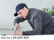 handsome young plumber fixing tap at cleints home. Стоковое фото, агентство Ingram Publishing / Фотобанк Лори