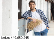 farmer stood in front of bails of hay. Стоковое фото, агентство Ingram Publishing / Фотобанк Лори