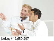 two men choosing colours from a swatch. Стоковое фото, агентство Ingram Publishing / Фотобанк Лори