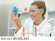 laboratory assistant with magnifier and test tube chemical liquid. Стоковое фото, агентство Ingram Publishing / Фотобанк Лори
