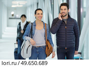 couple walking along passenger boarding bridge in airport. Стоковое фото, агентство Ingram Publishing / Фотобанк Лори