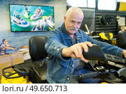 senior man trying trike in showroom. Стоковое фото, агентство Ingram Publishing / Фотобанк Лори