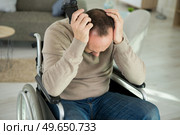 side view of sad man sitting on wheelchair. Стоковое фото, агентство Ingram Publishing / Фотобанк Лори