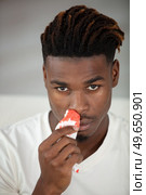 man with bleeding nose holds tissue to his nostril. Стоковое фото, агентство Ingram Publishing / Фотобанк Лори
