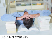Man resting head between two piles of books. Стоковое фото, агентство Ingram Publishing / Фотобанк Лори