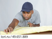 a plasterer measuring a padding. Стоковое фото, агентство Ingram Publishing / Фотобанк Лори