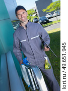 janitor holding a foldable ladder. Стоковое фото, агентство Ingram Publishing / Фотобанк Лори