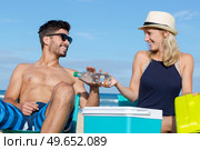 girlfriend giving a bottled water to partner while sunbathing. Стоковое фото, агентство Ingram Publishing / Фотобанк Лори
