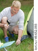 father putting up tent on camping trip. Стоковое фото, агентство Ingram Publishing / Фотобанк Лори