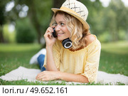 woman laying on blanket wearing headphones in the sunshine. Стоковое фото, агентство Ingram Publishing / Фотобанк Лори