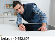a worker replacing the hob. Стоковое фото, агентство Ingram Publishing / Фотобанк Лори