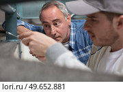 worker watching apprentice using screw writer. Стоковое фото, агентство Ingram Publishing / Фотобанк Лори