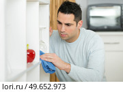 man cleaning dust from bookshelf. Стоковое фото, агентство Ingram Publishing / Фотобанк Лори