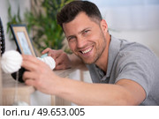 handsome young man mounting lamp. Стоковое фото, агентство Ingram Publishing / Фотобанк Лори