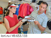 Couple looking at golfing visor. Стоковое фото, агентство Ingram Publishing / Фотобанк Лори