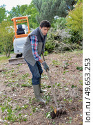 Man working in garden, digger in background. Стоковое фото, агентство Ingram Publishing / Фотобанк Лори