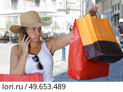 compulsive shopper sighing as she looks at her shopping bags. Стоковое фото, агентство Ingram Publishing / Фотобанк Лори
