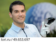 portrait of golfer posing with a ball on a field. Стоковое фото, агентство Ingram Publishing / Фотобанк Лори