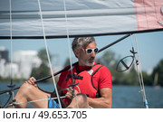 handsome young man sitting on a hobie cat. Стоковое фото, агентство Ingram Publishing / Фотобанк Лори